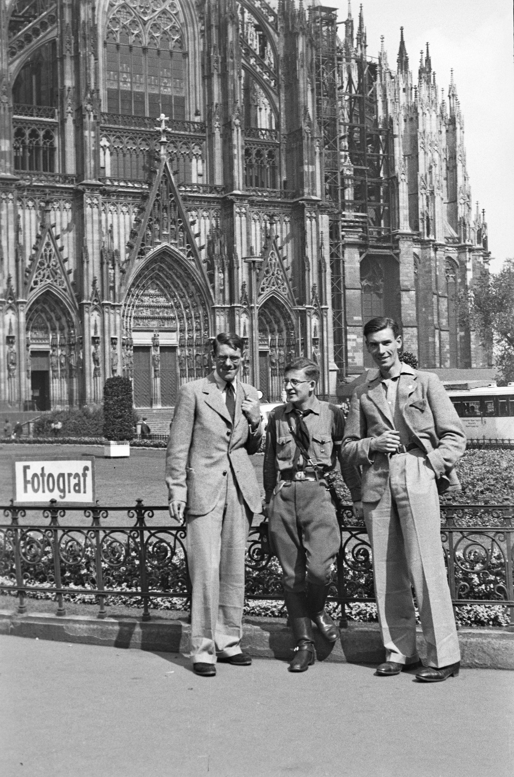 Drei junge Männer, einer in der Uniform der Hitlerjugend, in den 30er Jahren vor dem Kölner Dom