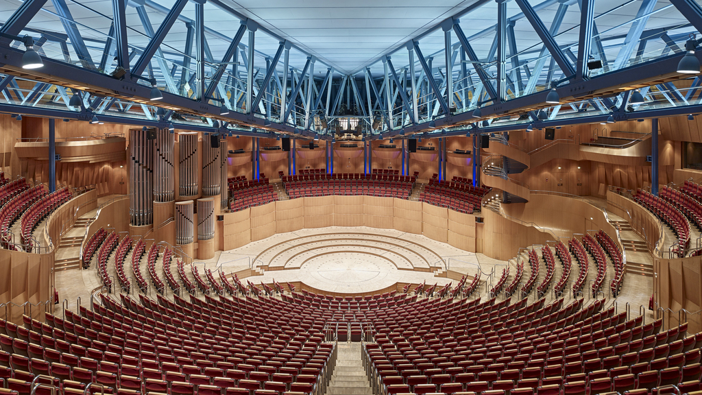 Foto der leeren Kölner Philharmonie. Im Vordergrund die Sitzreihen, im Hintergrund die Bühne für das Orchester.