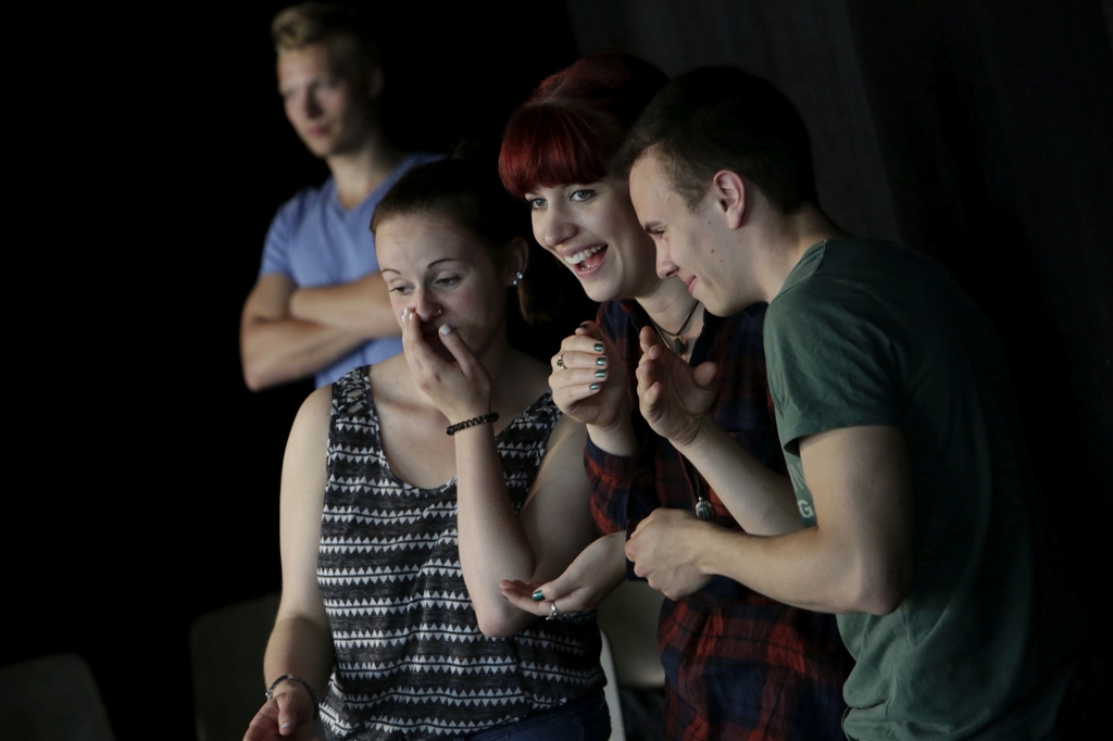 Drei lachende Menschen im Vordergrund