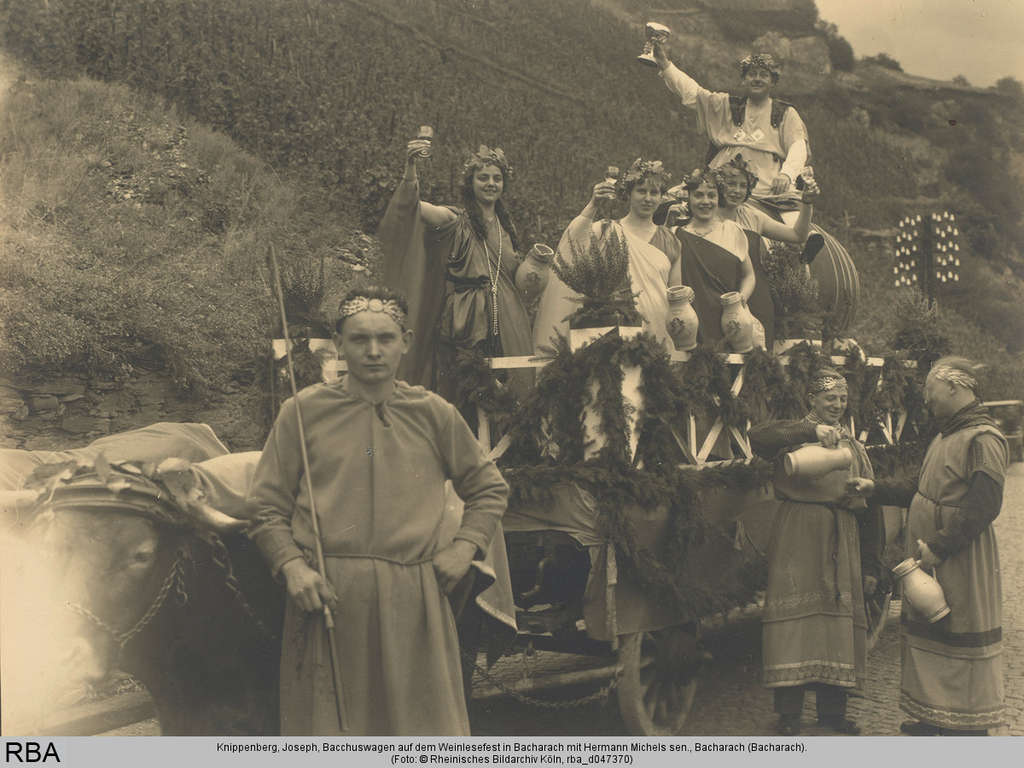 Bacchus-Weinlesefest in Bacharach um 1935, mit mehreren Feiernden in historischen Kostümen auf einem Wagen 