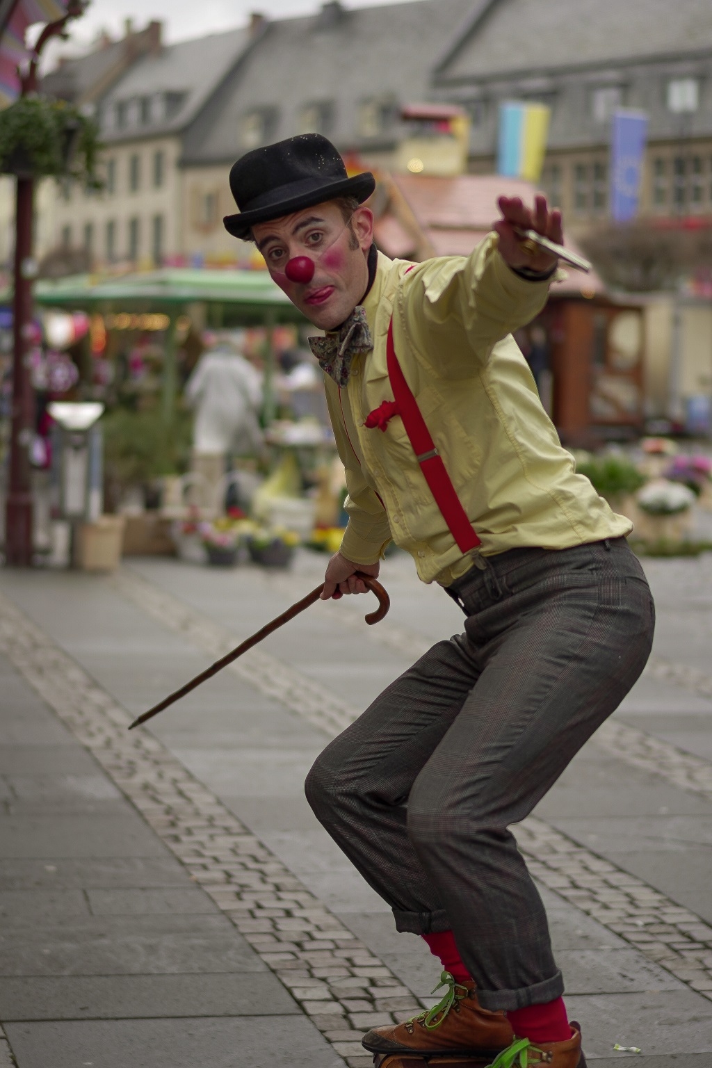 Clown mit Gehstock, Hut und roter Nase