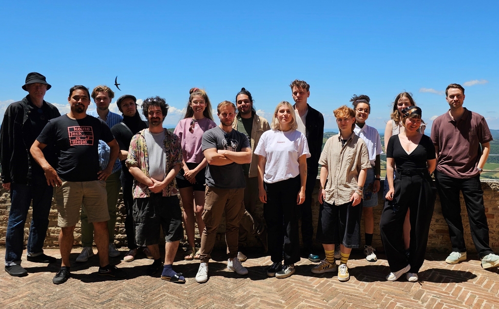 Eine Gruppe von Menschen fotografiert vor einer Landschaft