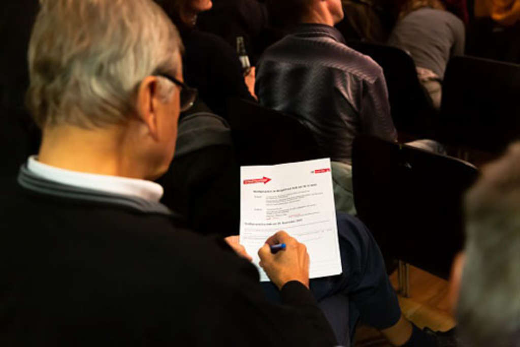 Blick über die Schulter eines Besuchers, der sich Notizen macht