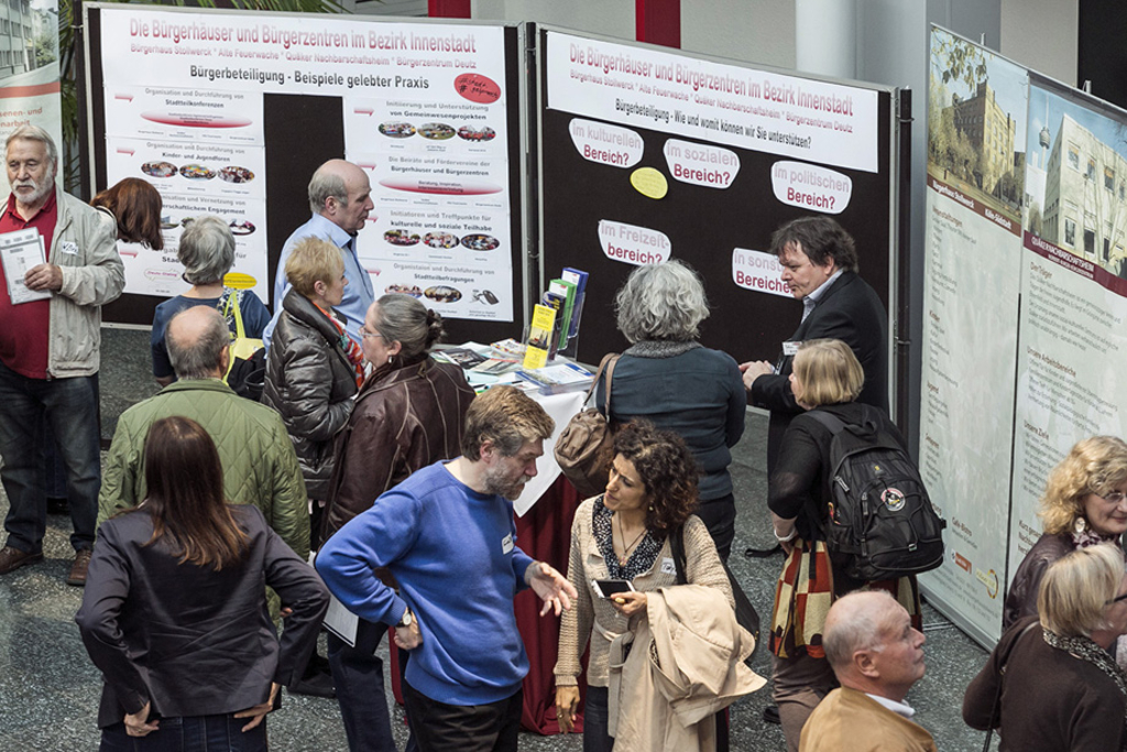 Interessierte gemeinsam im Gespräch vor den Stellwänden