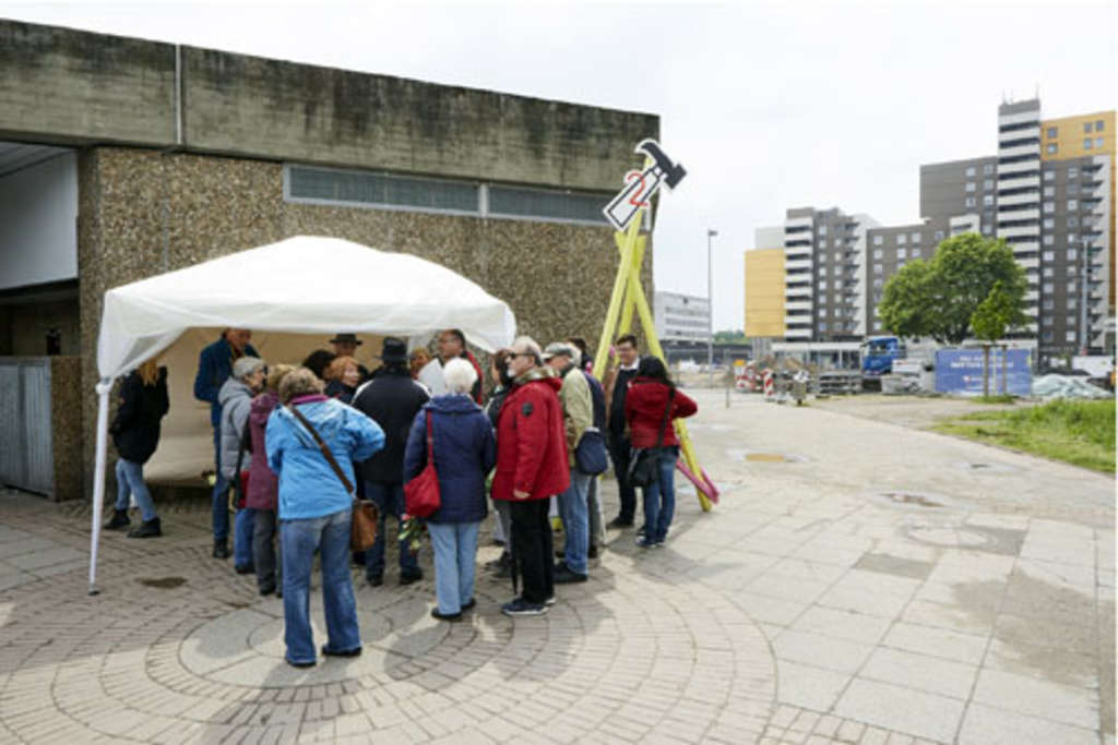 Eine Gruppe von Menschen steht vor einem Informationsstand