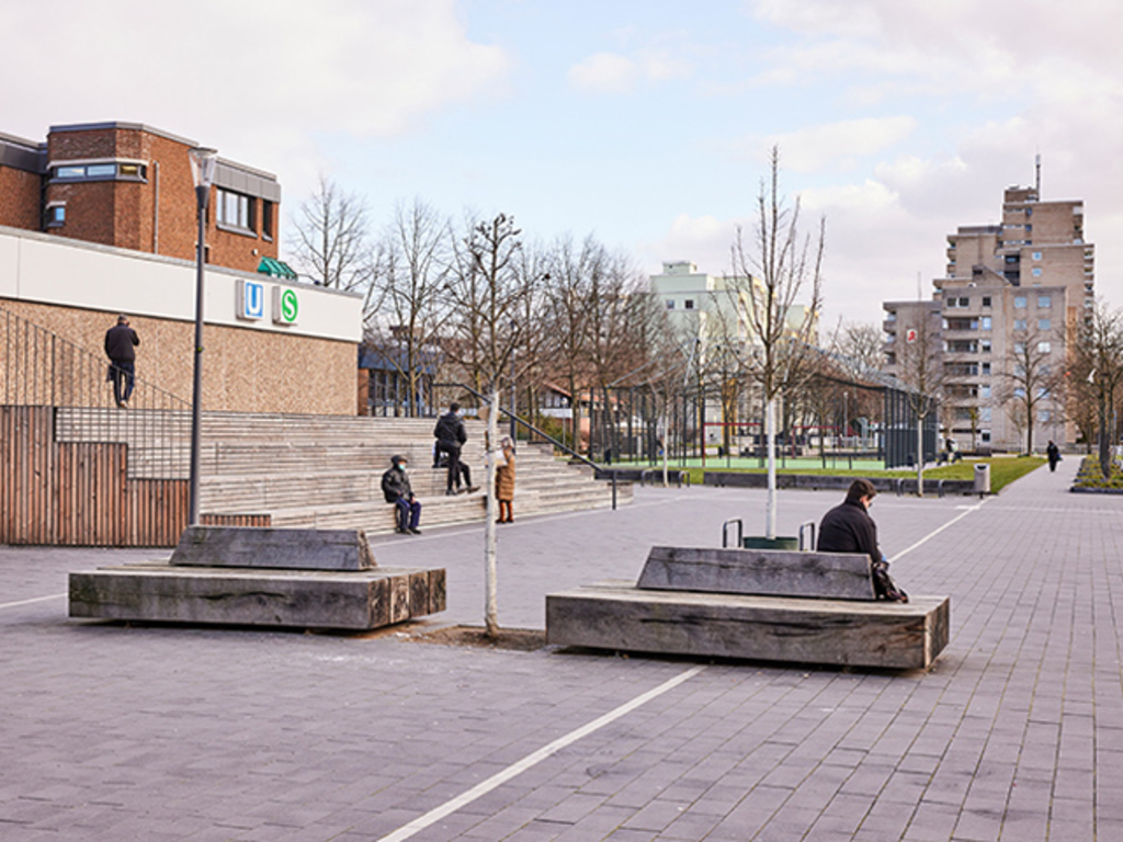 Sitzbänke und eine Tribüne im Bereich des Gebäudes der S-Bahn-Station Chorweiler auf dem Pariser Platz