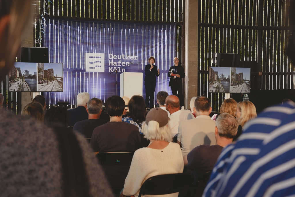 Auf einer Bühne am Hafentag steht OB Reker und ein Moderator in einer Interviewsituation. 