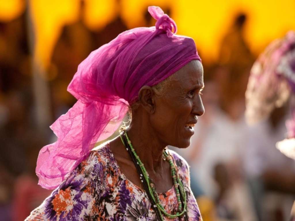 Afrikanerin im Profil mit rosa Kopftuch 