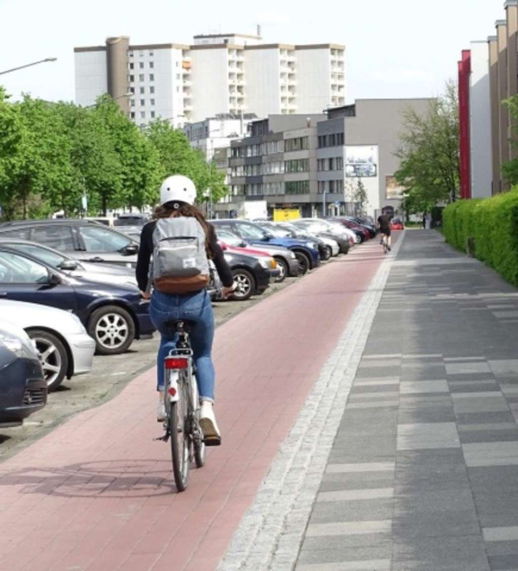 Radfahrerin fährt auf saniertem Radweg an der Alfred-Schütte-All