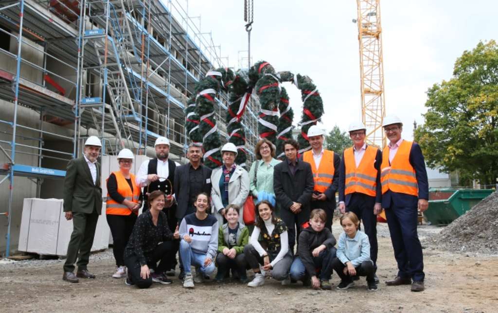 Vor dem Rohbau für die Erweiterung des Schiller-Gymnasiums stehen Vertreter der Stadtverwaltung, am Bau beteiligter Firmen sowie Vertretungen beider Schulgemeinschaften