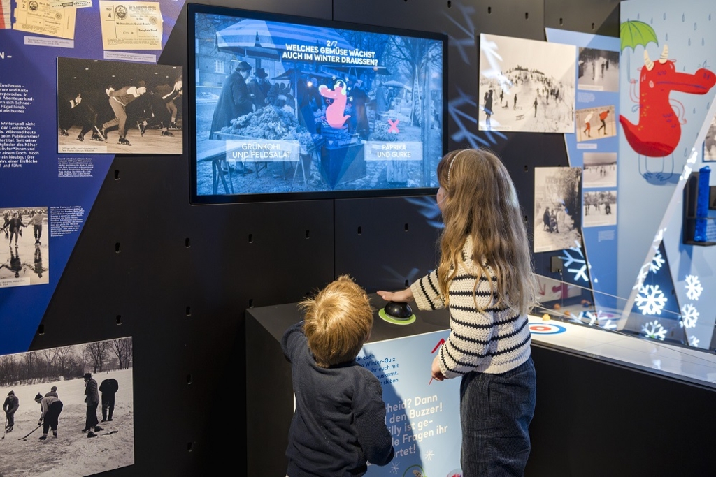 Ein kleines Kind und ein Mädchen spielen Winter-Quiz-Buzzer