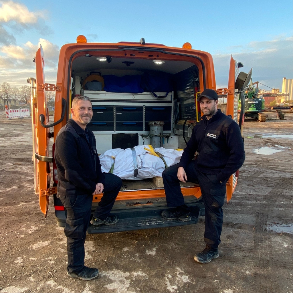 Foto von Marcel Biewald (links) und Michael Hilgers vom Kampfmittelbeseitigungsdienst Rheinland der Bezirksregierung Düsseldorf mit dem bereits zum Abtransport verpackten Blindgänger