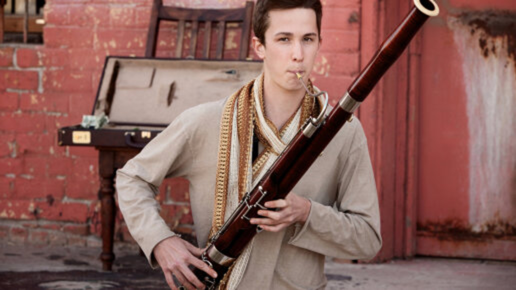 Junger Mann in indischer Kleidung spielt Fagott, Link auf Das Fagott - Stadt Köln