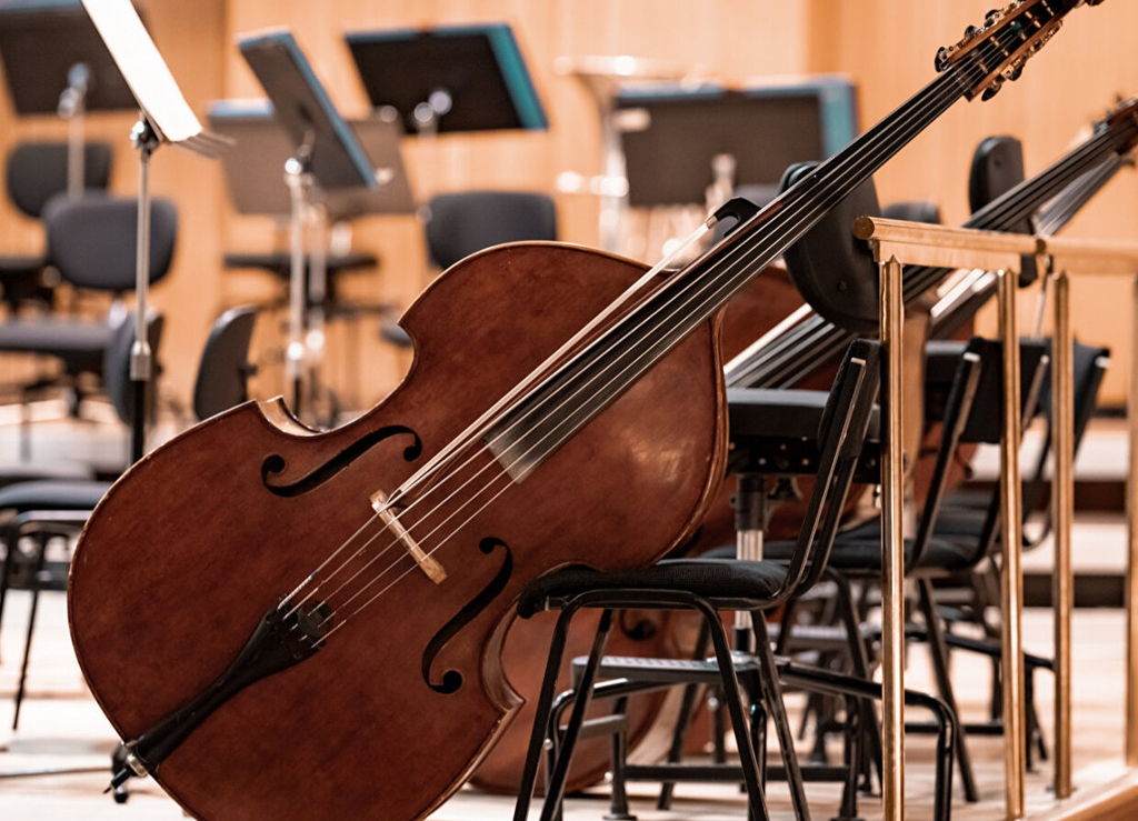 Kontrabass auf einer Bühne an einem Stuhl gelehnt