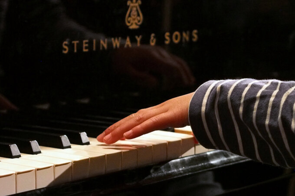 Kinderhände auf der Klaviatur eines Klavier, Link auf Regionalschulen der Rheinischen Musikschule - Stadt Köln