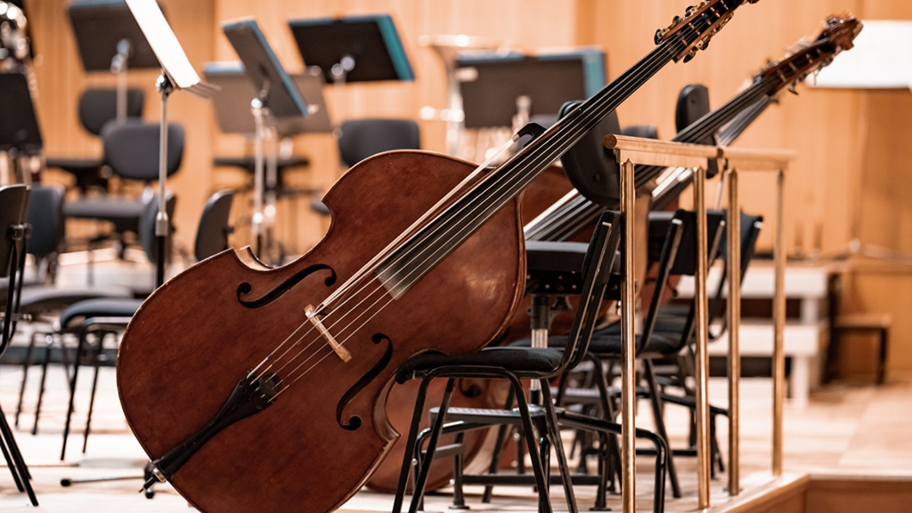 Kontrabass auf einer Bühne an einem Stuhl gelehnt