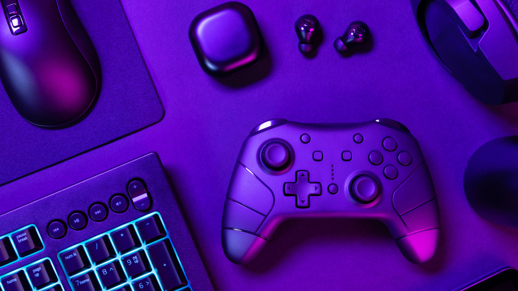 Blau beleuchtete Tastatur inmitten verschiedener Geräte auf einem schwarzen Tisch, das Bild ist in violetter Farbe.