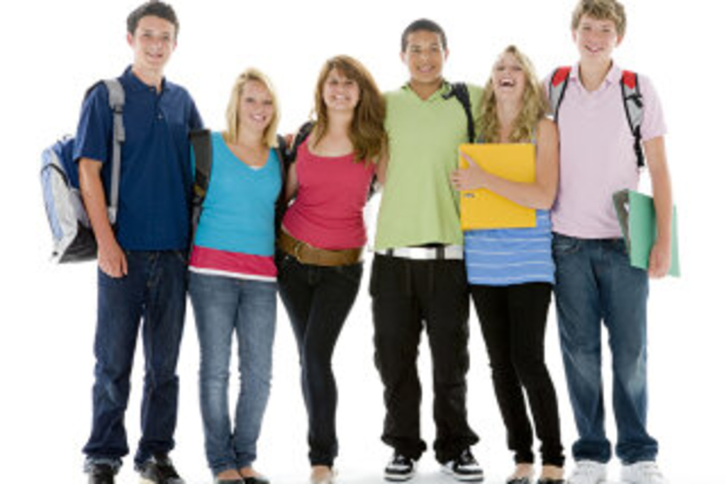 Gruppe von sechs Jugendlichen, die umarmt nebeneinander stehen mit Schulmappen und Rucksäcken