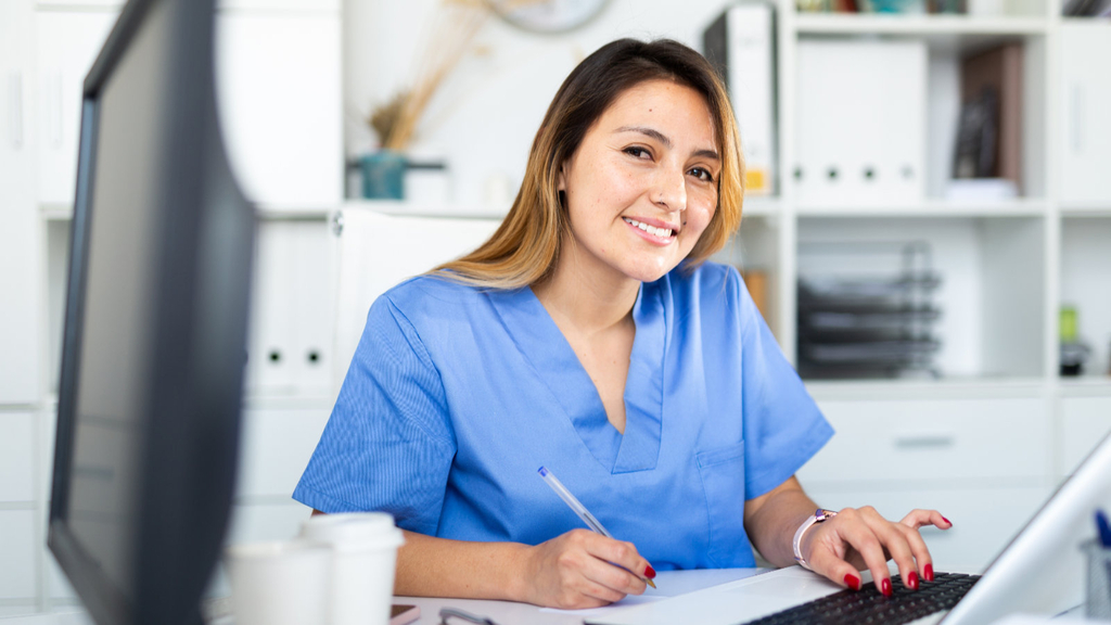 Medizinische Fachkraft arbeitet im Büro am Laptop