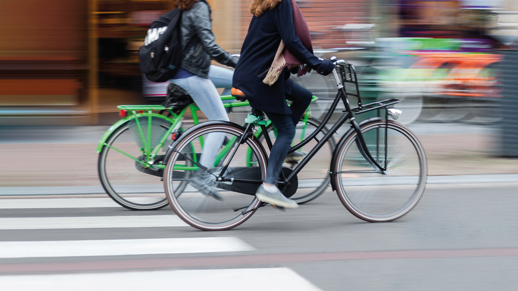 zwei Frauen auf Fahrrädern fahren schnell von links nach rechts, Link auf 6. Aktionstag Mobilität - Stadt Köln