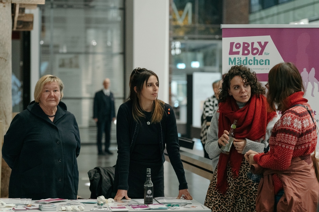 Infostand Lobby für Mädchen e. V. an dem drei Frauen stehen. 