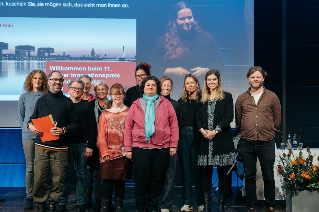 Vertreter*innen von KoKoBe stehen auf einer Bühne