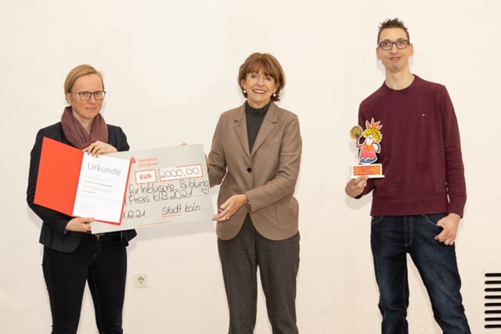 Oberbürgermeisterin Reker übergibt Kibbi, Urkunde und Scheck an Dr. Claudia Paul und Florian Lintz vom Projekt „Inklusive Bildung NRW“