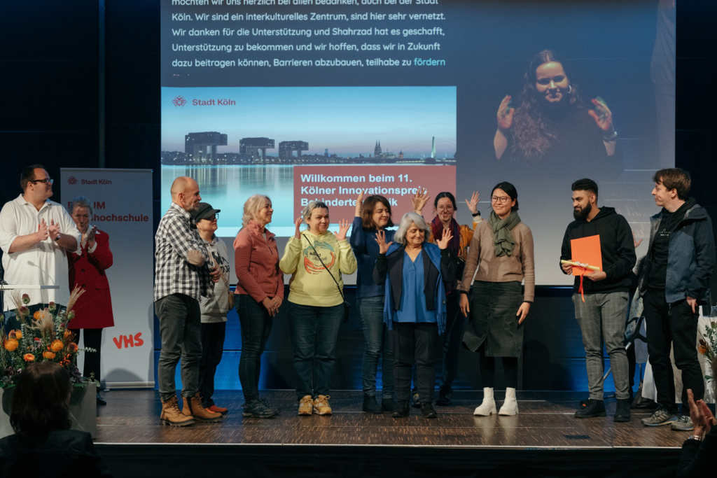 Vertreter*innen von Shahrzad e. V. stehen auf einer Bühne.