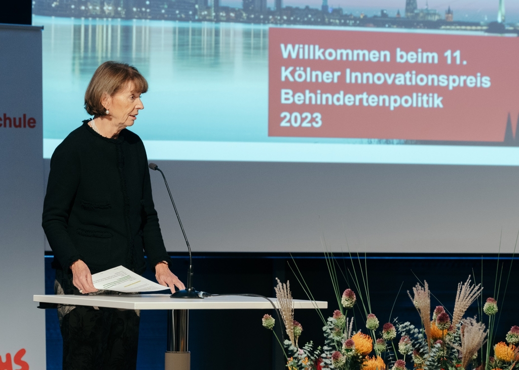 Oberbürgermeisterin Reker auf der Bühne hinter einem Rednerpult.