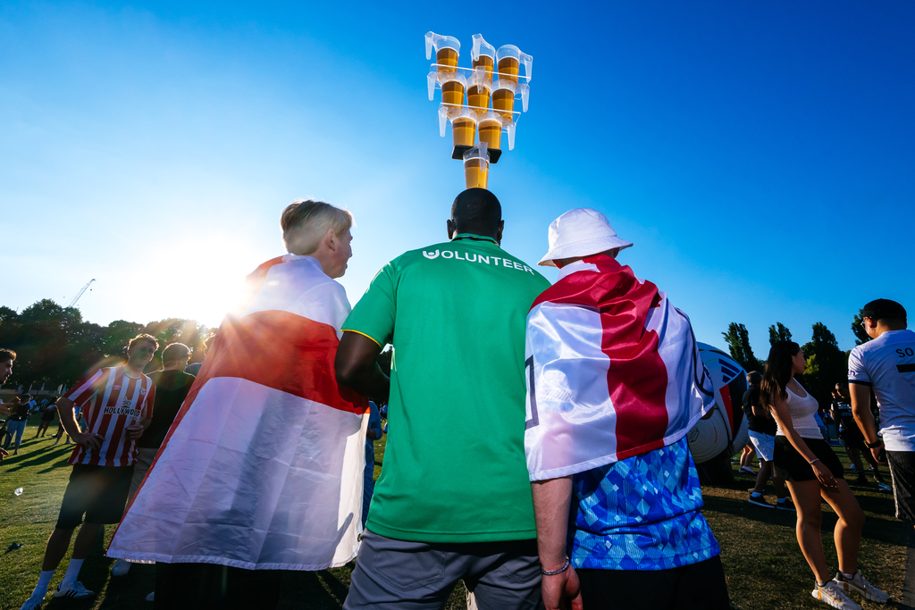 Volunteer versorgt die Fans mit Bier.
