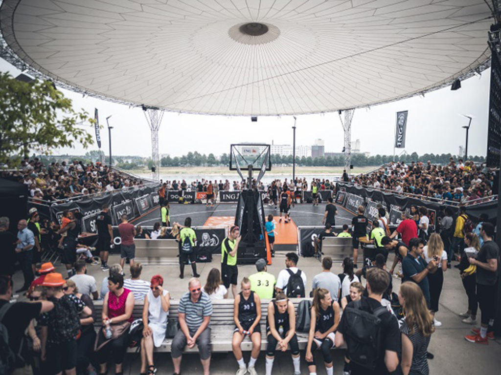 Bespielter Basketballcourt mit Zuschauern drum herum