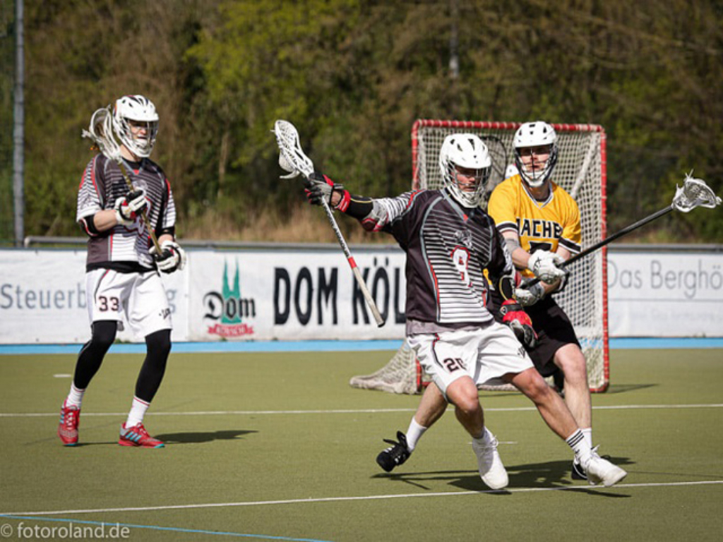 Lacrosse-Spielszene mit drei Spielern