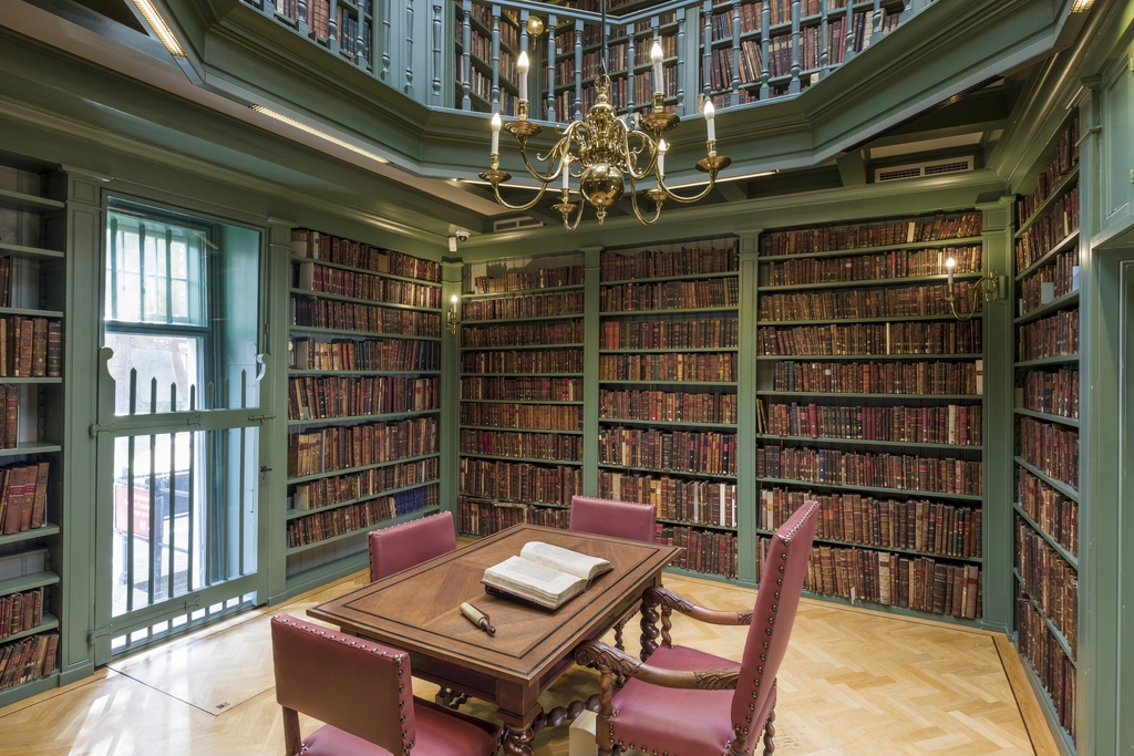 Raum voller Bücherregale mit Tisch und Stühlen in der Mitte / Library Ets Haim Livraria Montezinos