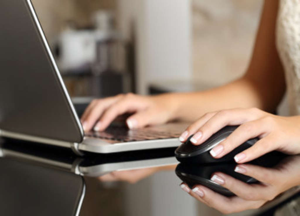 Laptop mit Frauenhände auf Tastatur und Maus