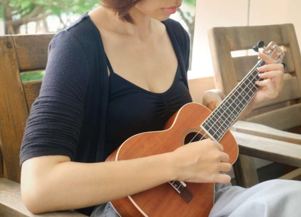sitzende Frau, die Ukulele spielt