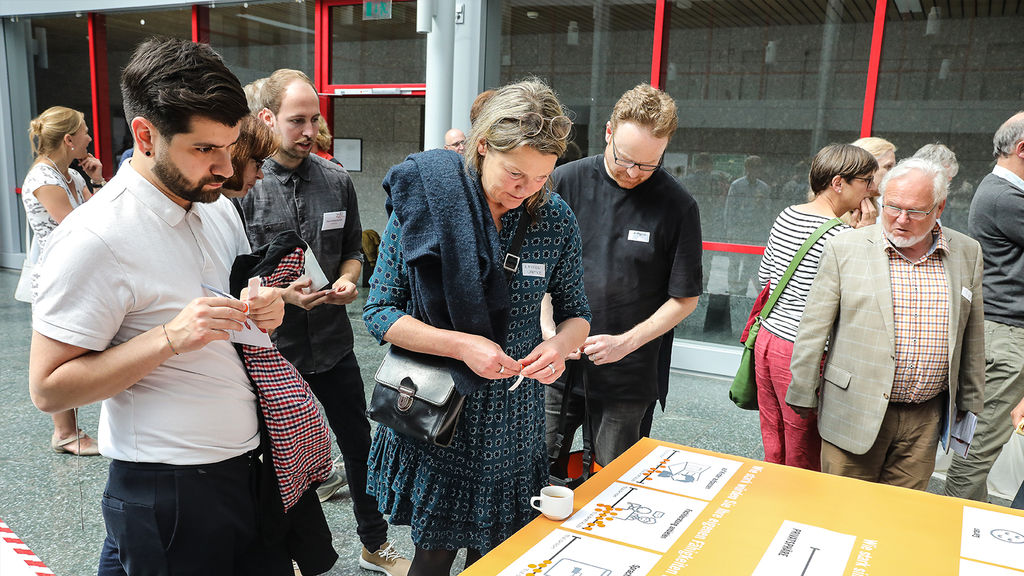 Das Foto zeigt Teilnehmende des ersten Zukunftsforums an einer Arbeitsstation.