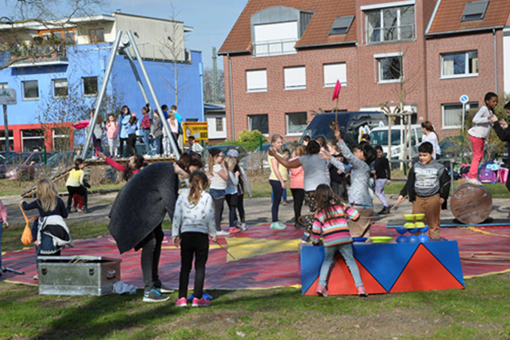 Kinder spielen auf dem neu eingeweihten Spielplatz am Pingenweg