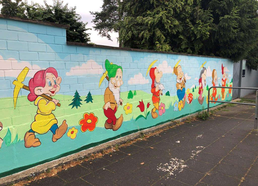 Wand mit bunten Märchenmotiven