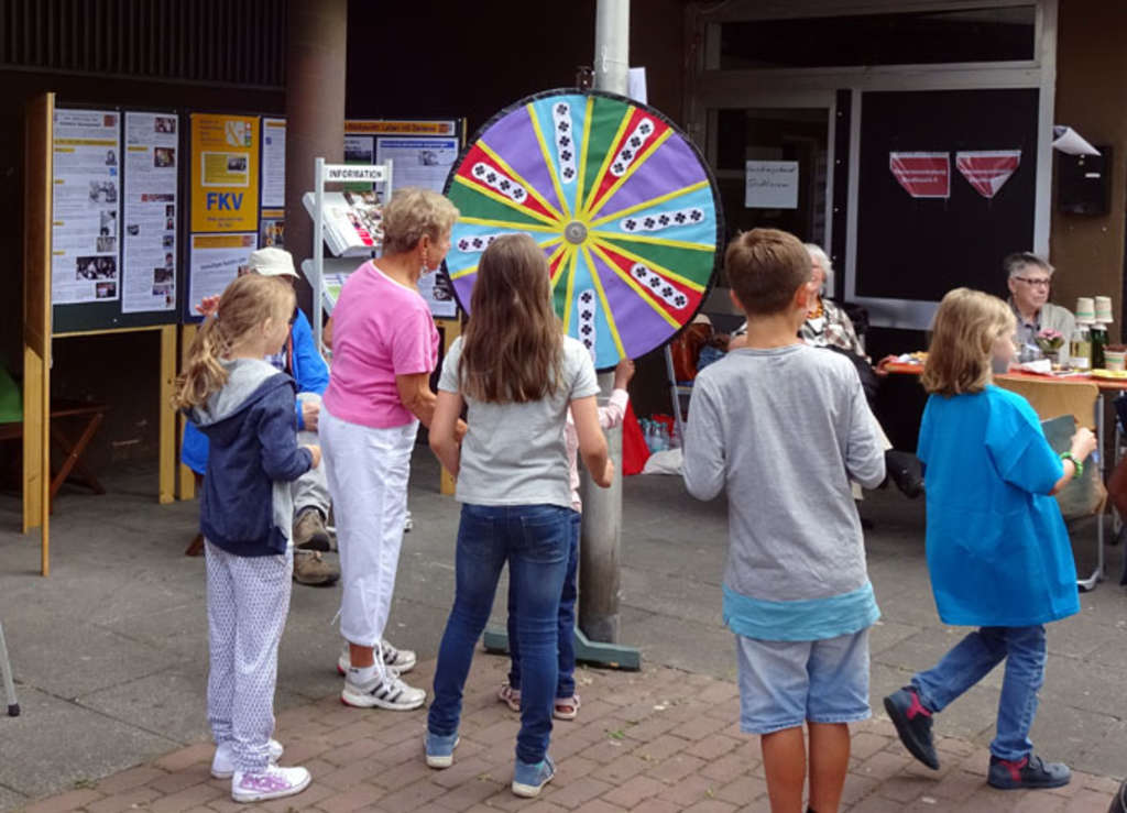 Kinder drehen beim Stadtteilfest am Glücksrad 