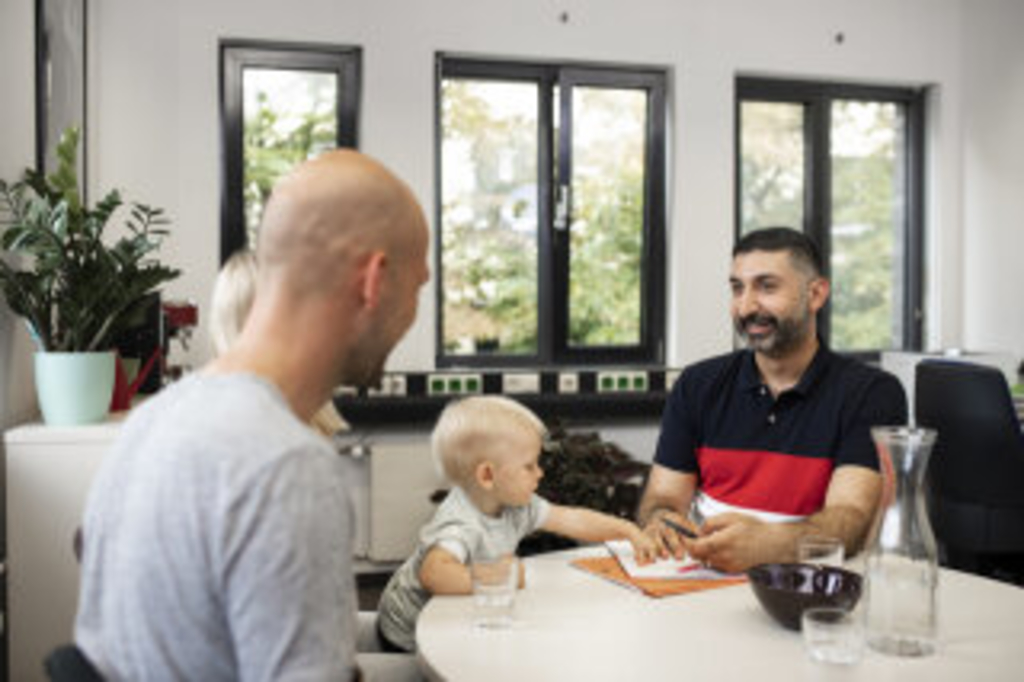 Ein Sozialpädagoge im Gespräch mit einer Familie, Link auf Sozialarbeit und Sozialpädagogik