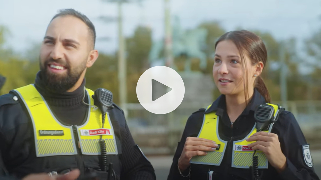 Zwei Kolleg*innen vom Ordnunsdienst bei einem Gespräch mit einem*r Bürger*in, Link auf Mach Köln korrekter – Bewirb dich jetzt beim Ordnungsdienst der Stadt Köln - YouTube