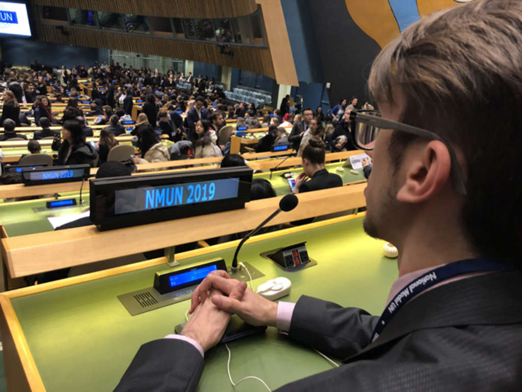 NMUN - National Model United States - Foto eines Sprechers von hinten in den Raum mit vielen jungen Leuten, die an Pulten sitzen