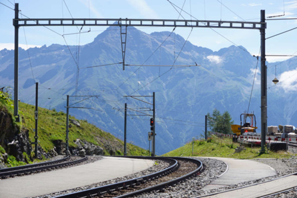 Foto aus dem Bernina Express von den Bahnschienen, im Hintergrund Berge