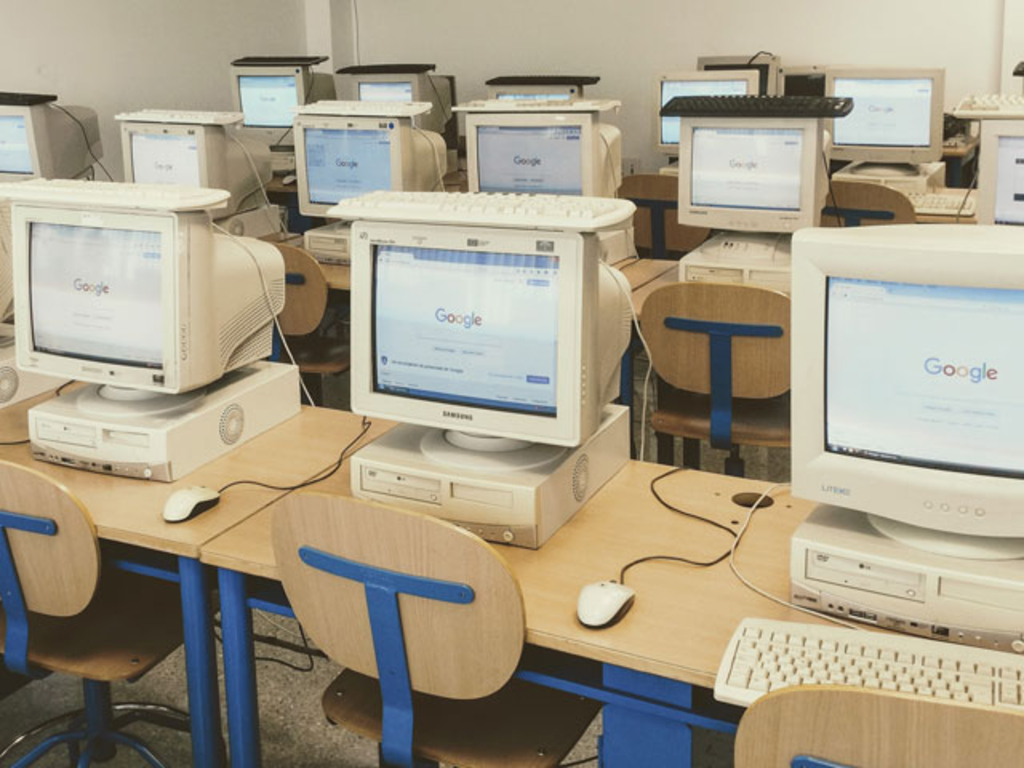 Alte Computer stehen auf den Tischen in einem Computerraum, die Tastaturen liegen oben auf den Bildschirmen