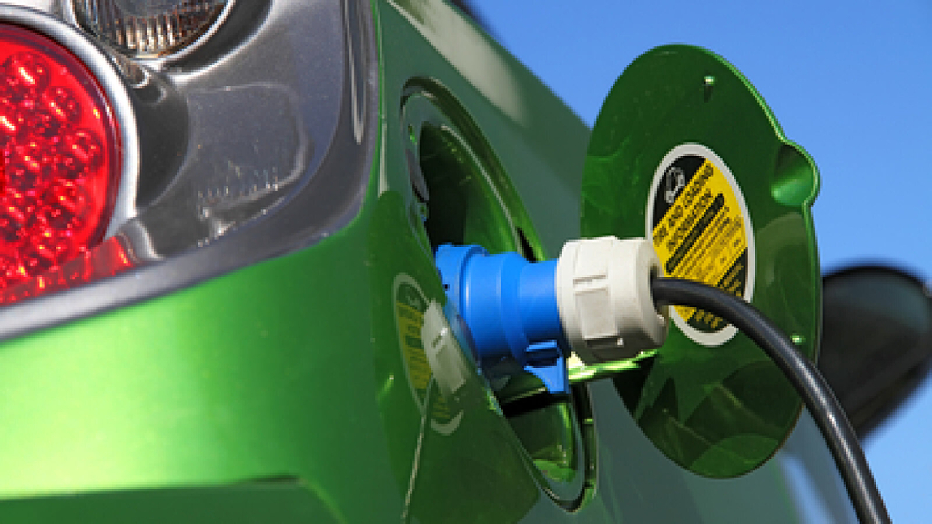 grünes Elektroauto beim Ladevorgang, Link auf Häufig gestellte Fragen zum Ausbau der E-Ladeinfrastruktur