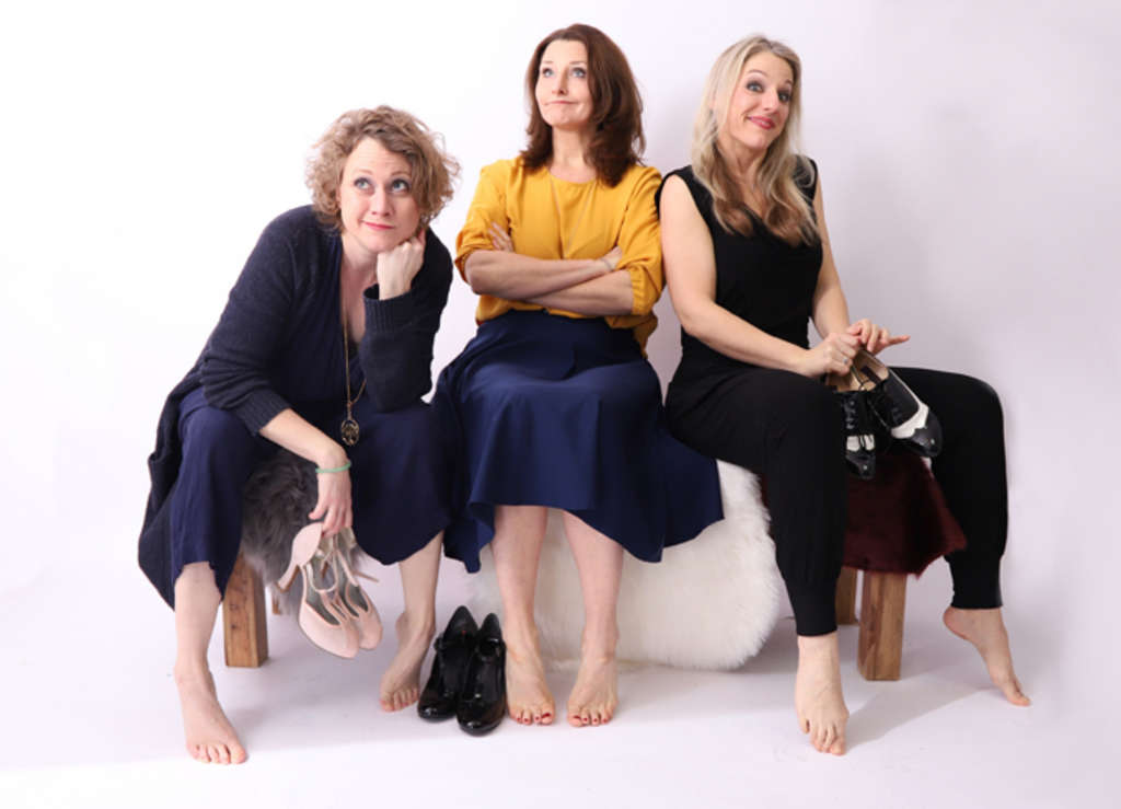 Michèle Connah, Stefanie Görtemöller und Claudia Wölfel de Mejia sitzen auf einer flauschigen Bank und schauen verschmitzt