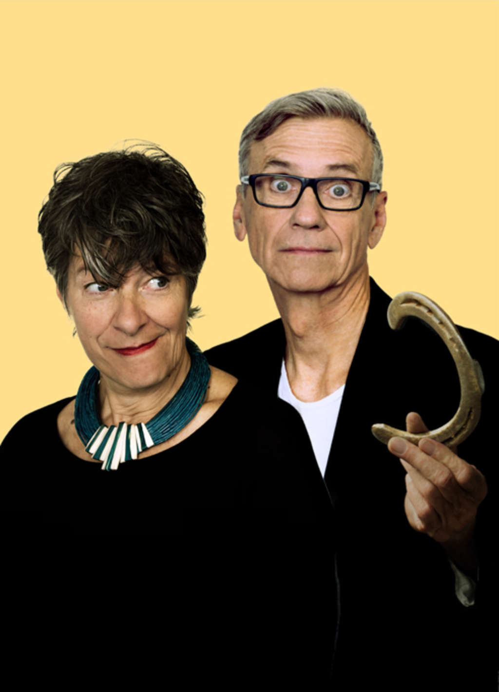 Duo Faltsch und Wagoni. Mann hält ein verbogenes Hufeisen. Frau schaut verschmitzt darauf.