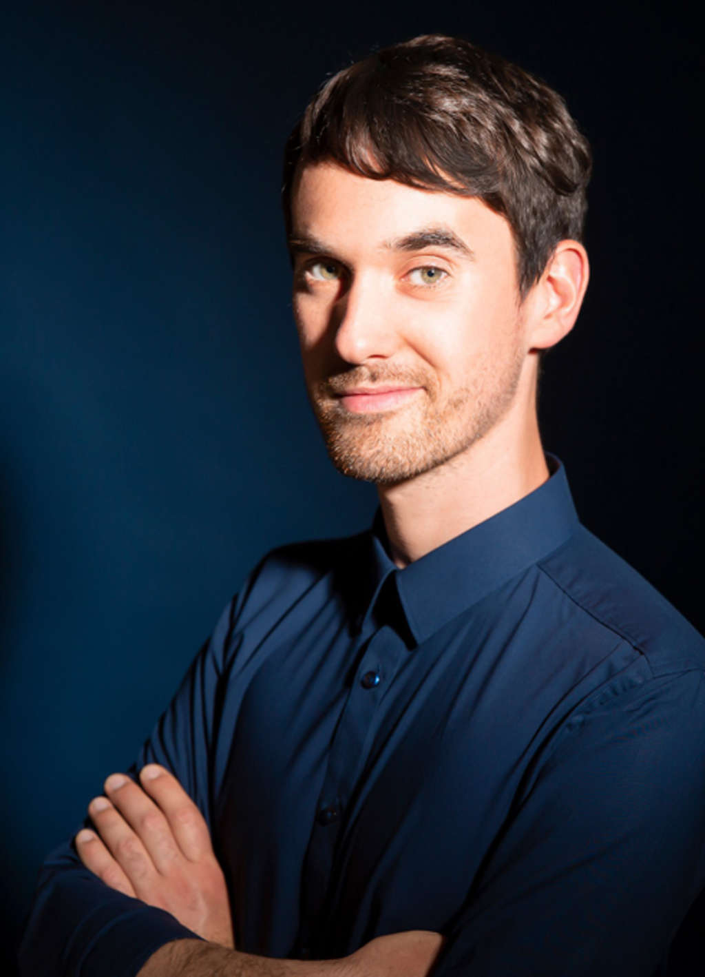 Michael Feindler in blauem Hemd und verschränkten Armen.