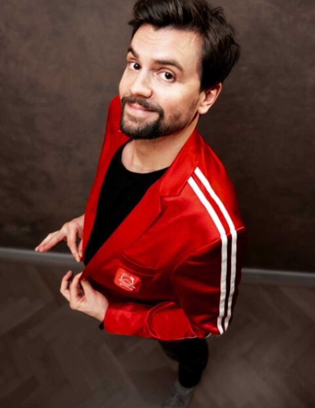 David Werker in rotem Jacket schaut lächelnd nach oben