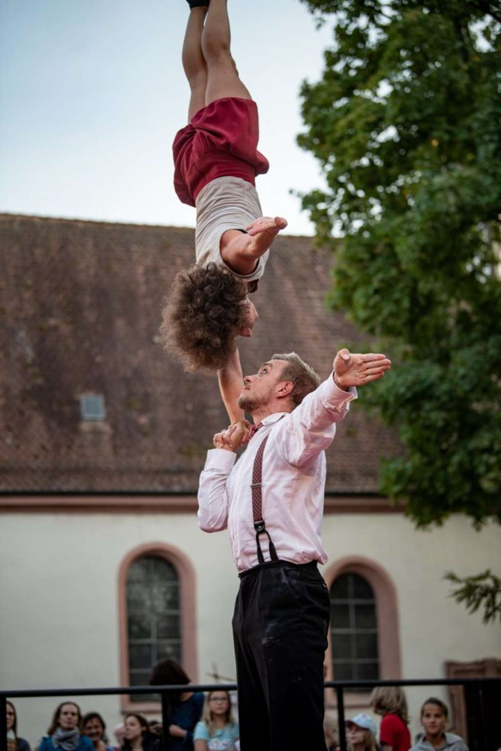 Mann hält Frau mit einer Hand kopfüber 